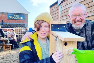 Boy and father, holding a nest box they just build in ipswich