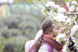A young girl smelling blossom