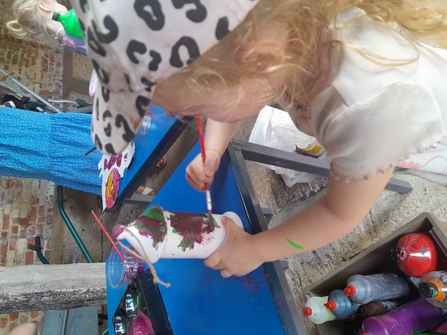 child painting bird feeders