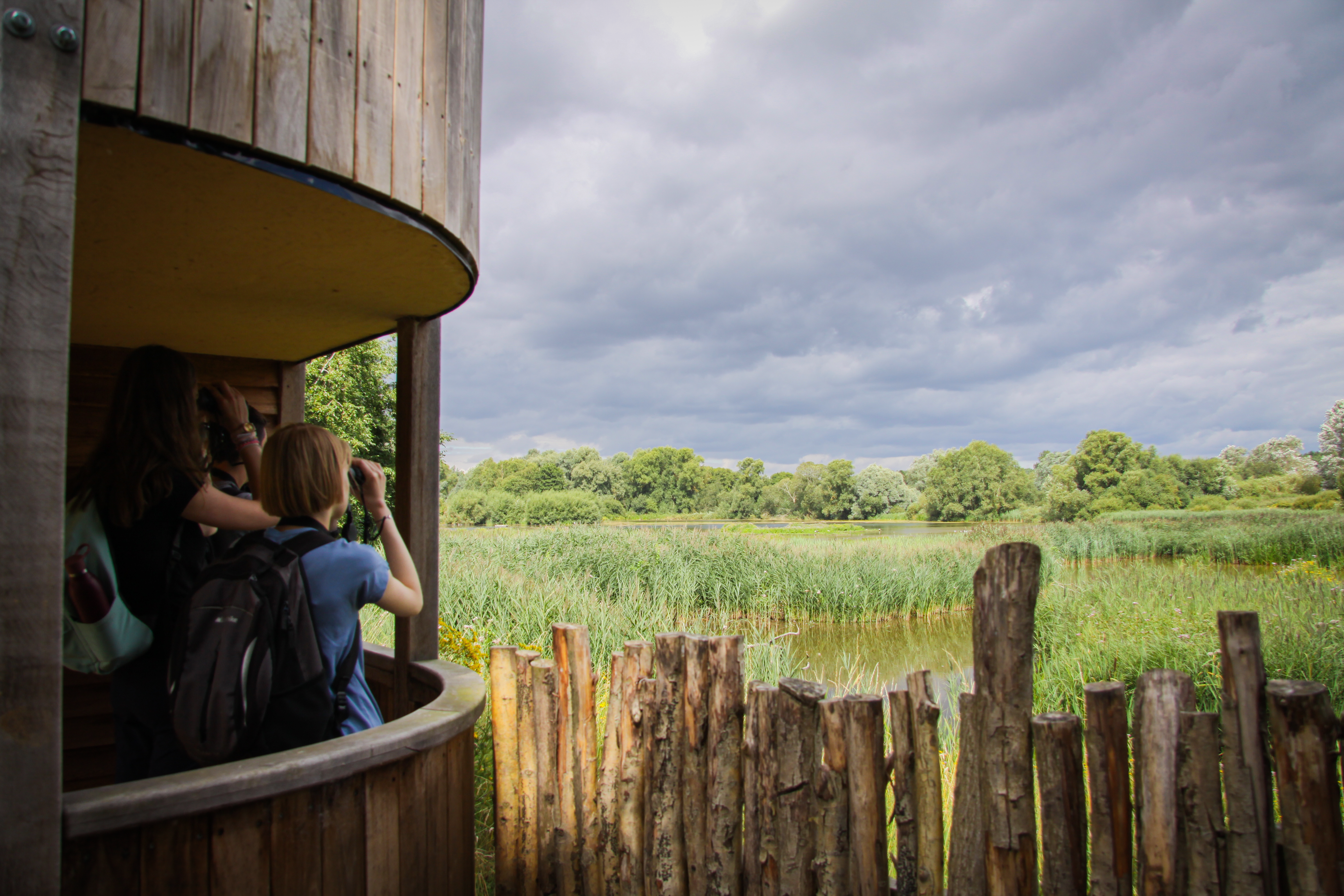 Young people looking through binoculars across the lakes