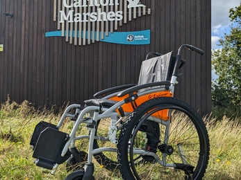 An off-road wheelchair outside the Carlton Marshes Visitor Centre 