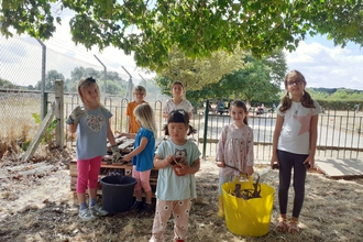 Seven children collecting items to build homes for wildlife