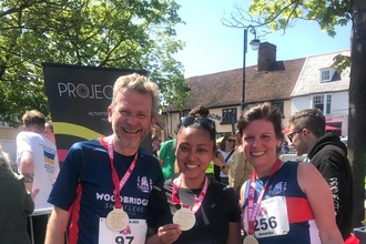 Runners proudly showing off their medals