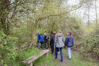 The Youth Board members walking away past tress and hedges at Foxburrow Nature Reserve