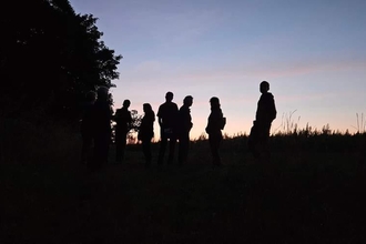 Outlines of people against the sunset