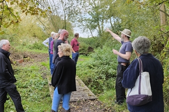 A group of people talking in the woodland