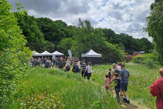 People walking along a grassy path to the Suffolk Wildlife Trust Stands at the Suffolk Show