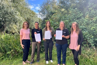 Wilder Ecology team members holding certificates