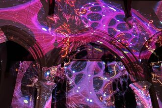 Large bright pink shapes projected onto a church inside wall