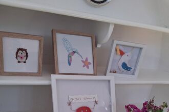 A selection of hand sewn art pieces in frames