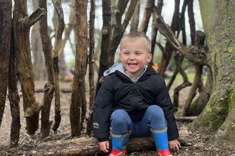 Wild Tot sitting in a den