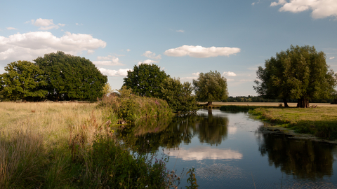 A view of the River Deben winding through the sunny countryside of the Stour Valley in Suffolk