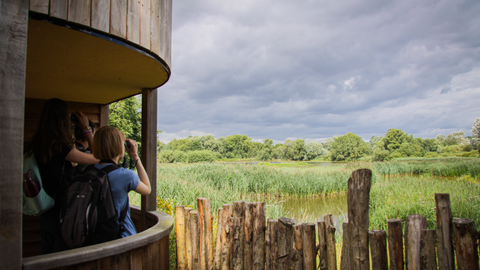 Young people looking through binoculars across the lakes