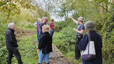 A group of people talking in the woodland