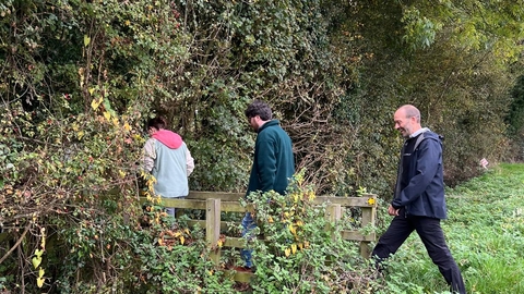 Team members crossing a footbridge