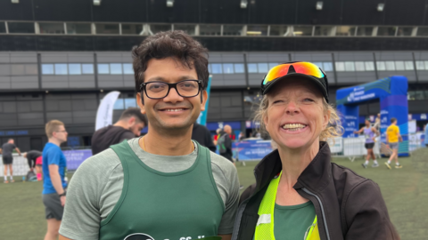 Partha and Sophie in Ipswich Town Football Stadium smiling at the camera 