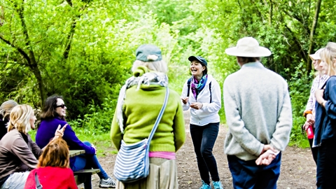 A group of people in a woodland talking and laughing