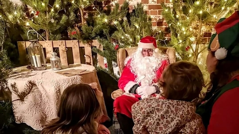 Father Christmas in his grotto at Foxburrow talking with a family