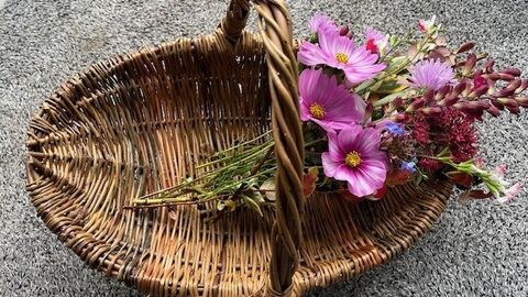 willow basket with pink flowers lying on it