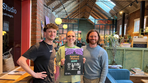The team at New Street Market holding a festival poster