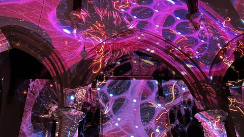 Large bright pink shapes projected onto a church inside wall