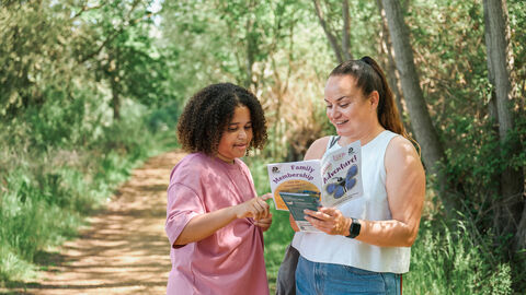 Woman and child look at a leaflet on a nature trail