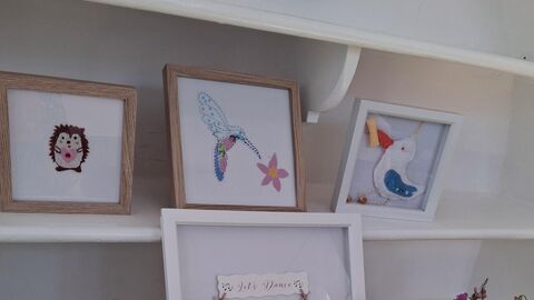 A selection of hand sewn art pieces in frames