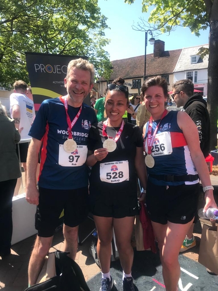 Runners proudly showing off their medals