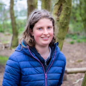 Hannah, Youth board member, standing by trees, image credit Simply C Photography