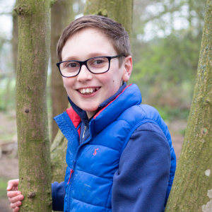 Henry, Youth Board member, standing by a tree