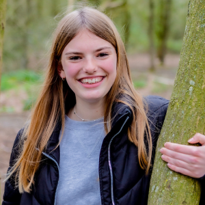 Evie, Youth Board member, standing by a tree, image credit Simply C Photography