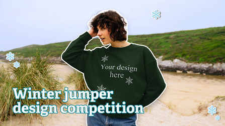 Person standing on a beach wearing a jumper which reads 'Your Design Here' and a headline saying 'Winter jumper design competition'