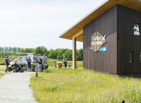 Suffok Wildlife Trust staff standing infront of the Carlton Marshes visitors centre talking to members of the public.