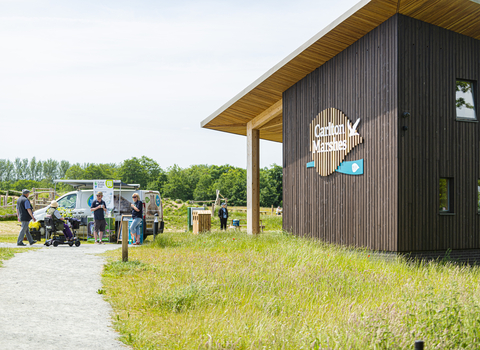 Suffok Wildlife Trust staff standing infront of the Carlton Marshes visitors centre talking to members of the public.