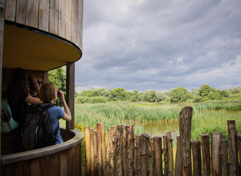 Young people looking through binoculars across the lakes