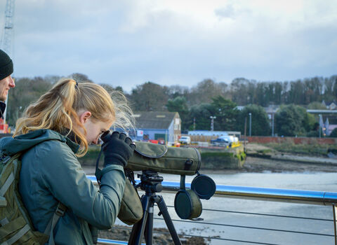Georgia looking through a scope onto the River Orwell