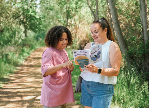 Woman and child look at a leaflet on a nature trail